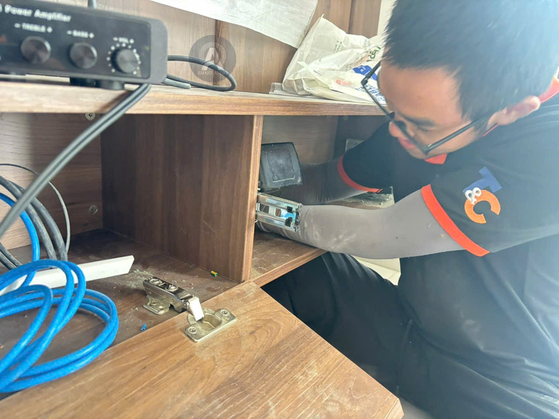 Kỹ thuật viên kiểm tra đấu nối thiết bị âm thanh trong tủ căn hộ