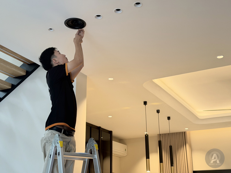 Kỹ thuật viên kiểm tra cụm loa ở vị trí lắp trên trần